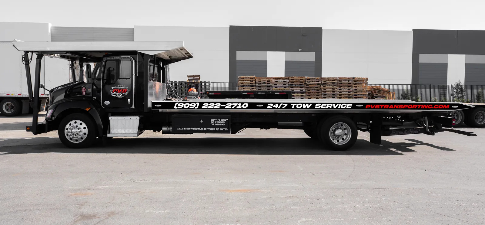 PVB Transport flatbed recovery truck with the deck tilted, ready to winch a vehicle on